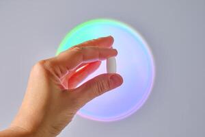 Tablet in hand against the background of a glowing circle. photo