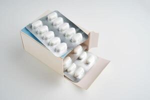 Open pack of pills on a white background. photo