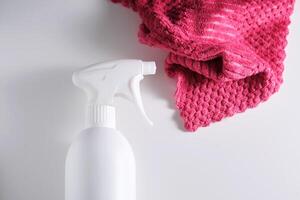 Cleaning product with a sprayer on a background of a red microfiber cloth. photo