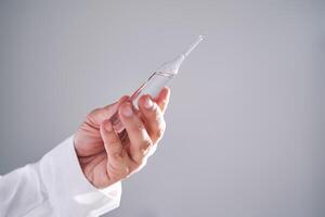 The doctor holds an ampoule with medicine. Close-up. photo