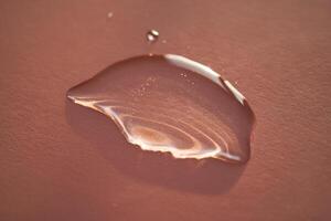 Beautiful volumetric drop of cosmetic product on a pink background. photo