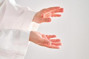 Female hands in a white robe stretch to the right. photo