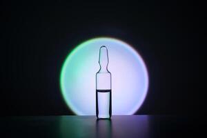 Ampoule for injection against the background of a bright blue circle. photo