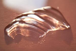 Beautiful volumetric drop of cosmetic product on a pink background. photo