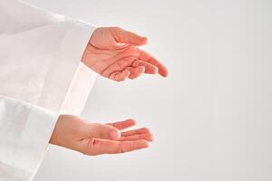 Female hands in a white robe stretch to the right. photo