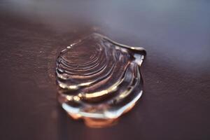 Beautiful volumetric drop of cosmetic product on a dark purple background. photo