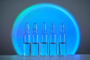 Several ampoules for injection with medicines on a blue background. photo
