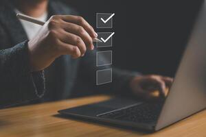 Business performance checklist, businessman use laptop doing online checklist survey, filling out digital form checklist, take an assessment, evaluation, online survey, questionnaire, online exam. photo