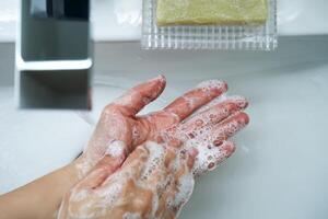 The process of washing hands with natural soap over the sink. photo