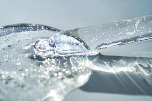 Pipette with serum shimmering in the sun on a blue background. photo