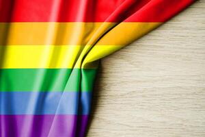 rainbow flag or LGBTQ, with a wooden background and copy space for text. 3d illustration. photo