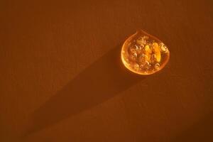 Drop of serum shimmering in the sun on a beige background. photo