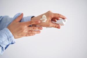 Hands in a blue shirt hold a tube of cream. photo