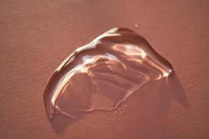 Beautiful volumetric drop of cosmetic product on a pink background. photo