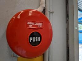 Manual call point tool for fire alarm system, red installed on the wall photo