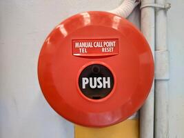 Manual call point tool for fire alarm system, red installed on the wall photo