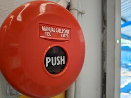 Manual call point tool for fire alarm system, red installed on the wall photo