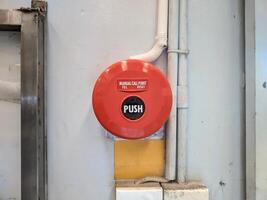 Manual call point tool for fire alarm system, red installed on the wall photo