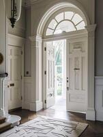 Entrance to a historic manor, framed by antique architectural elements and flanked by potted topiaries, features an aged door photo