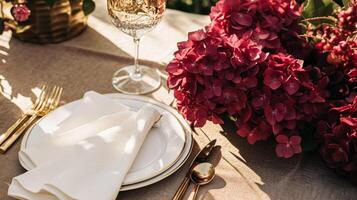 Wedding or formal dinner holiday celebration tablescape with hydrangea flowers in the English countryside garden, table setting and wine, floral table decor for family dinner party, home photo