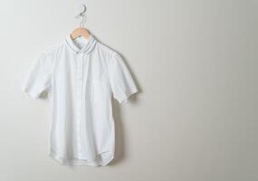 hanging shirt with wood hanger on wall photo