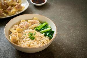 egg noodles with pork wonton soup or pork dumplings soup and vegetable photo
