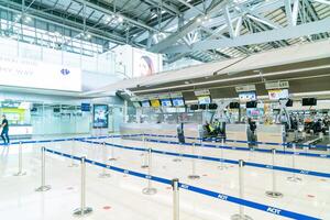 bangkok, tailandia - 23 de mayo de 2022 - pasajeros del aeropuerto suvarnabhumi de bangkok dentro de la terminal de salida, personas con máscaras médicas de coronavirus. foto