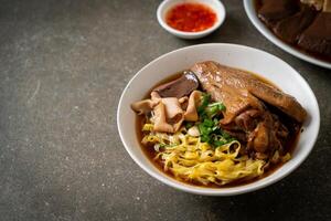 egg noodles with stewed and braised duck in brown soup photo