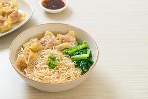egg noodles with pork wonton soup or pork dumplings soup and vegetable photo