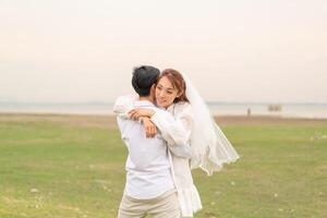 Happy young Asian couple in bride and groom clothing photo