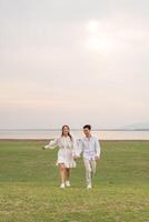 Happy young Asian couple in bride and groom clothing photo