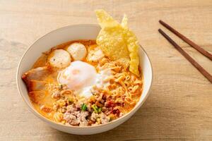 instant noodles with pork and meatballs in spicy soup photo