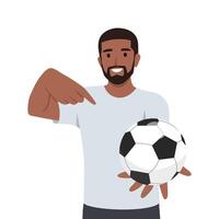 Young man holds out hand with soccer ball and points finger at it. vector