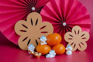 Chinese New Year of the dragon festival concept. Mandarin orange, red envelopes, dragon and gold ingot with red paper fans. Traditional holiday lunar New Year. photo