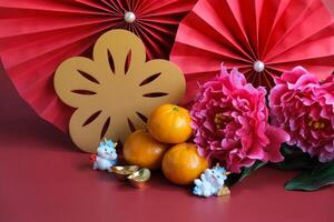 Chinese New Year of the dragon festival concept. Mandarin orange, red envelopes, dragon and gold ingot with red paper fans. Traditional holiday lunar New Year. photo