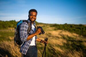 joven hombre disfruta utilizando prismáticos y excursionismo en naturaleza foto