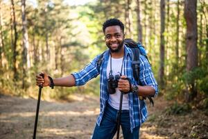 joven hombre disfruta excursionismo en naturaleza. foto