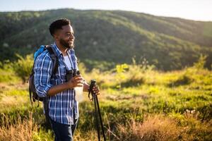 Young man enjoys hiking and drinking energy drink. photo