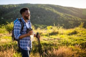 joven hombre disfruta excursionismo y Bebiendo energía beber. foto