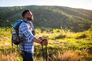 joven hombre disfruta excursionismo en naturaleza. foto