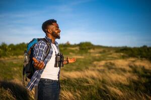 contento hombre caminante con brazos elevado disfruta en el naturaleza foto