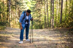 caminante tiene tiene lesión en pierna mientras excursionismo en el naturaleza. foto