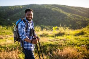 joven hombre disfruta excursionismo en naturaleza. foto