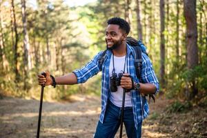 joven hombre disfruta excursionismo en naturaleza. foto