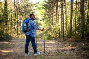 joven hombre disfruta excursionismo en naturaleza. foto