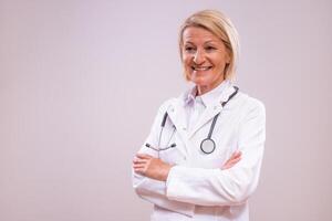 Portrait of mature female doctor on gray background. photo