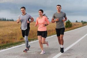 A group of friends, athletes, and joggers embrace the early morning hours as they run through the misty dawn, energized by the rising sun and surrounded by the tranquil beauty of nature photo