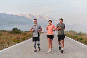 A group of friends, athletes, and joggers embrace the early morning hours as they run through the misty dawn, energized by the rising sun and surrounded by the tranquil beauty of nature photo