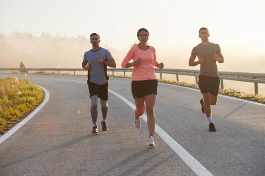 A group of friends, athletes, and joggers embrace the early morning hours as they run through the misty dawn, energized by the rising sun and surrounded by the tranquil beauty of nature photo