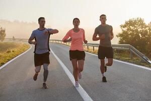 A group of friends, athletes, and joggers embrace the early morning hours as they run through the misty dawn, energized by the rising sun and surrounded by the tranquil beauty of nature photo